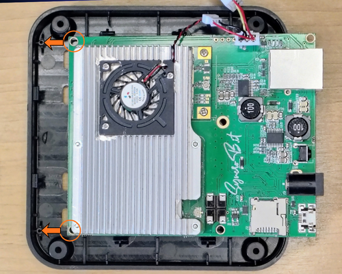 Slide the front-edge holes over the plastic mounting posts in the bottom of the case and press the board down to snap it in