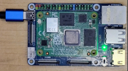 IO board connected to the PC via USB-C with the green power LED lit